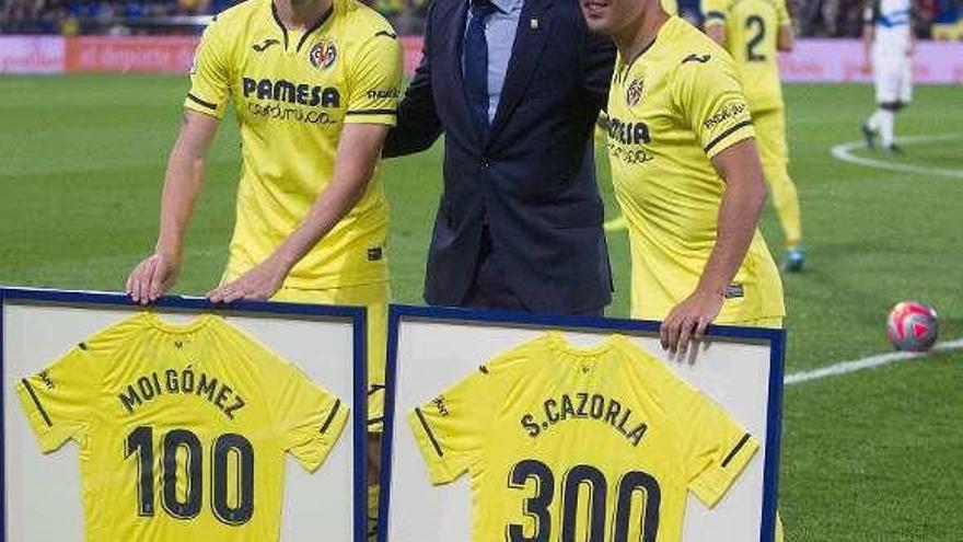 Marcos Senna, director de Relaciones Institucionales del Villarreal, entre Cazorla y Moi Gómez, homenajeados por sus 300 y 100 partidos en el club.