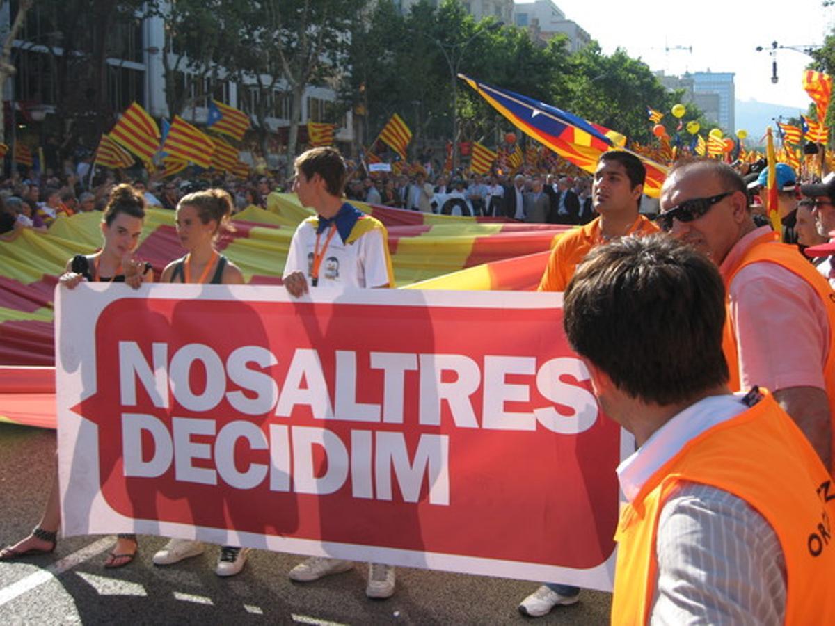 Unos jóvenes sostienen una pancarta con uno  de los lemas principales de la protesta: ’Nosaltres decidim’.