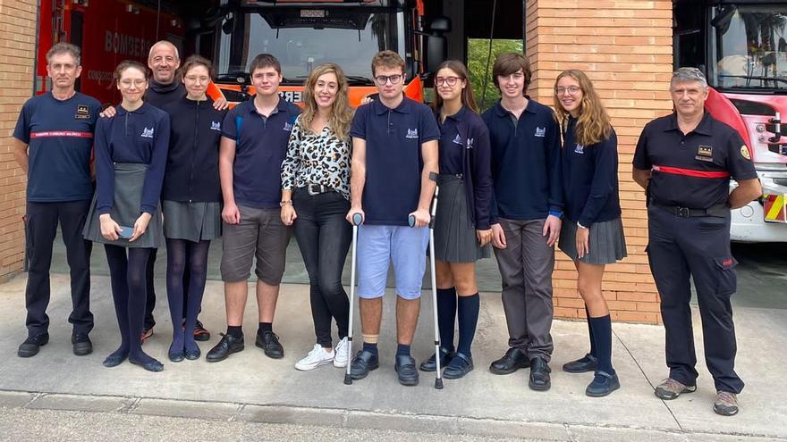 El alumnado y la profesora, autores de la aplicación, con varios bomberos en el parque de Gandia