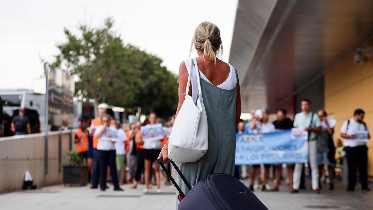 Una viajera sale de la terminal del aeropuerto de Ibiza, donde se produjo la última concentración.