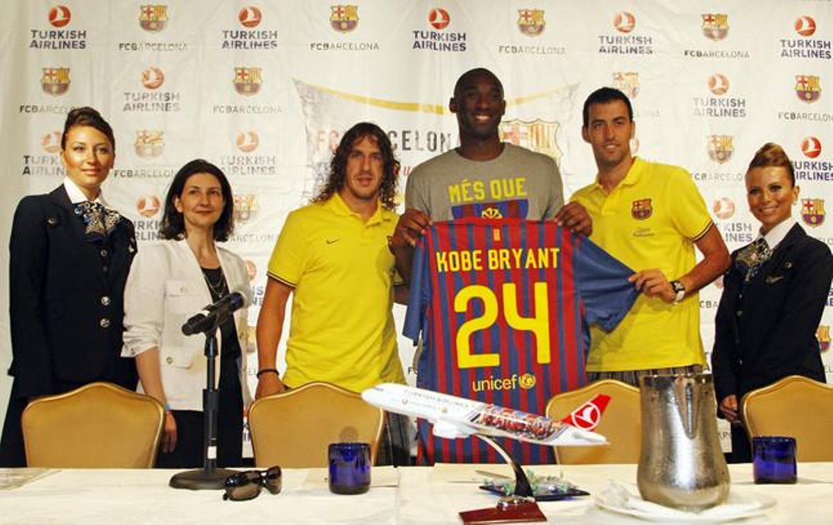 Kobe Bryant, entre Puyol i Busquets, mostra la samarreta del Barça amb el seu nom i el número 24 que li ha regalat el club blaugrana.