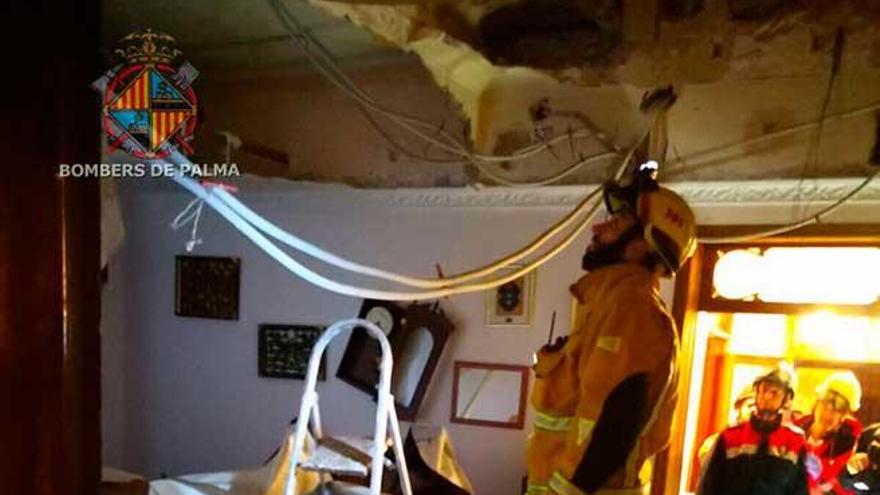 Un bombero inspecciona el agujero que se ha formado tras venirse abajo el techo de la casa.