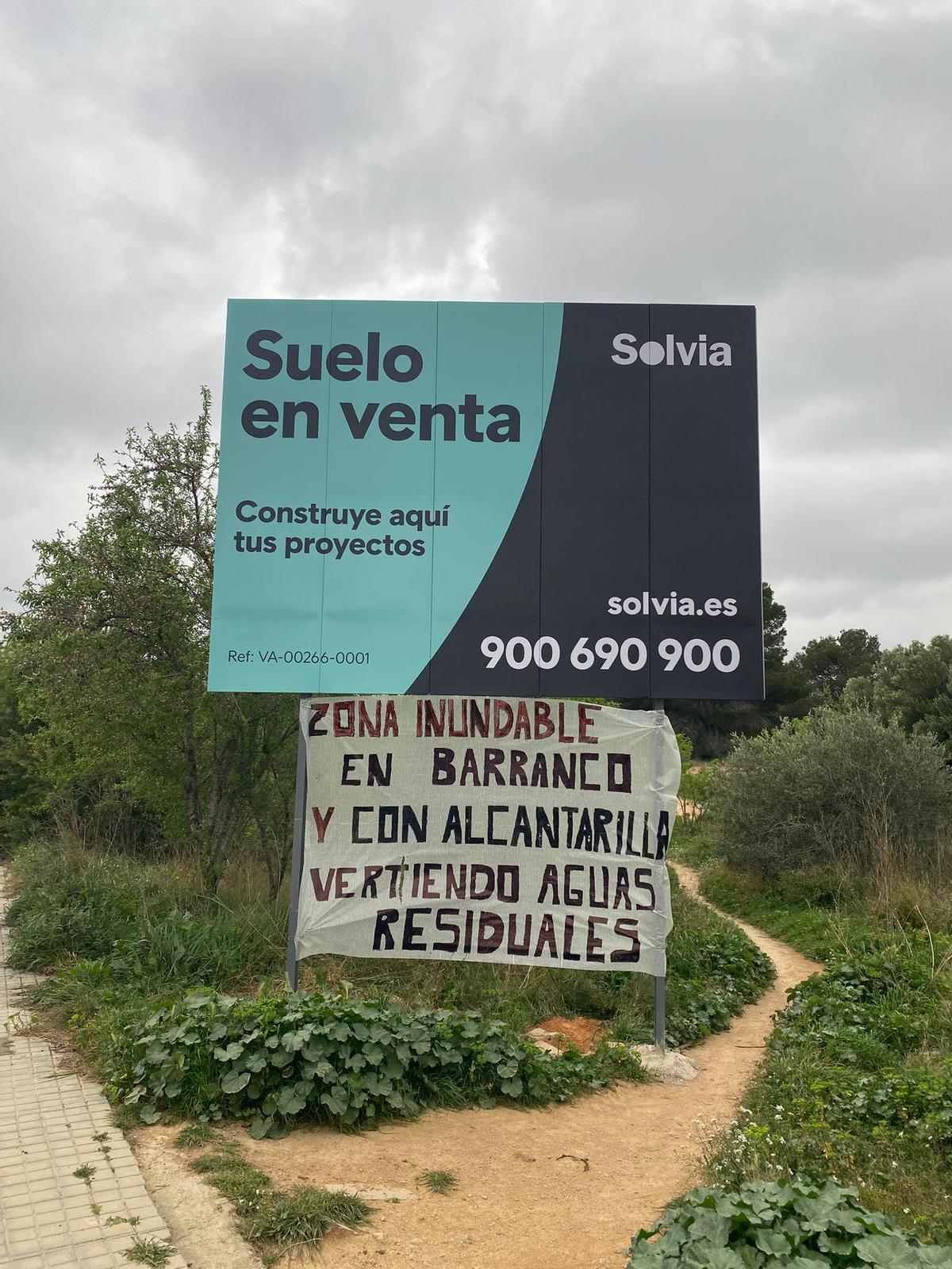 Un cartel que indica que el solar está disponible y debajo una de las pancartas compartidas por la plataforma.