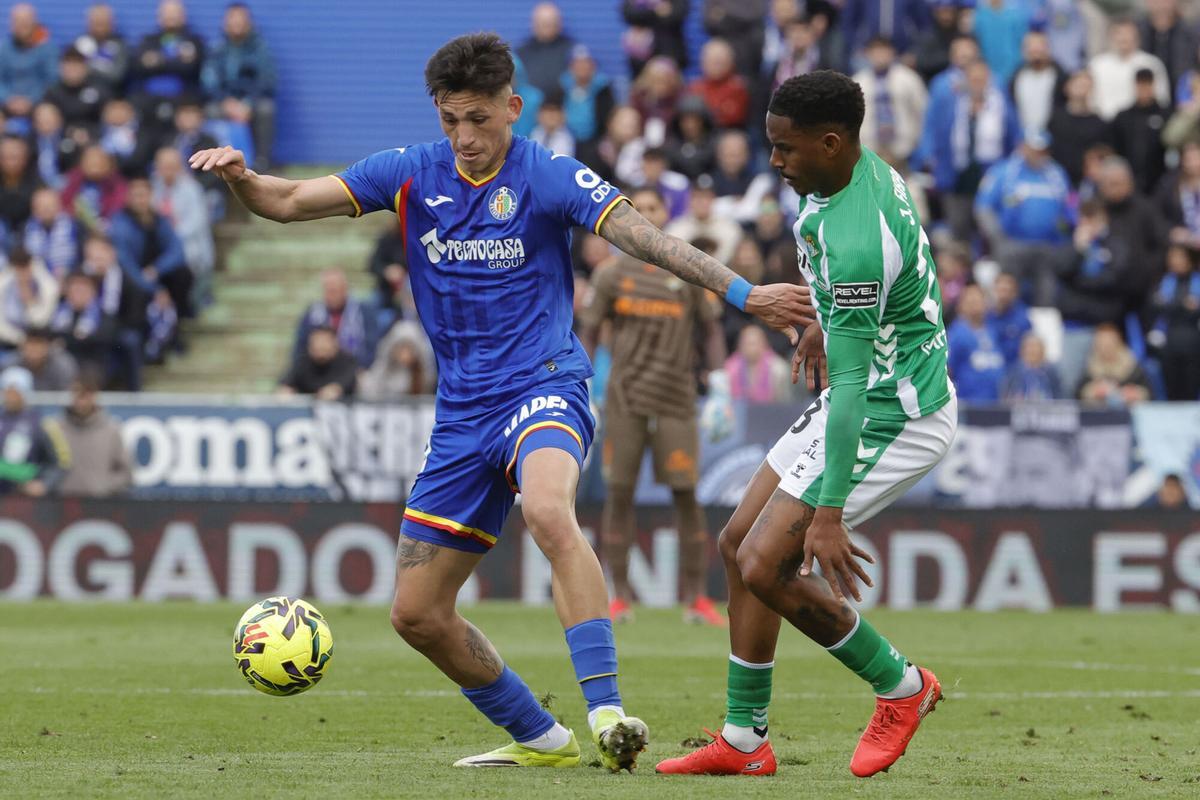El delantero dominicano del Betis Júnior Firpo (d) pelea un balón con el defensa argentino del Getafe Zaid Romero.
