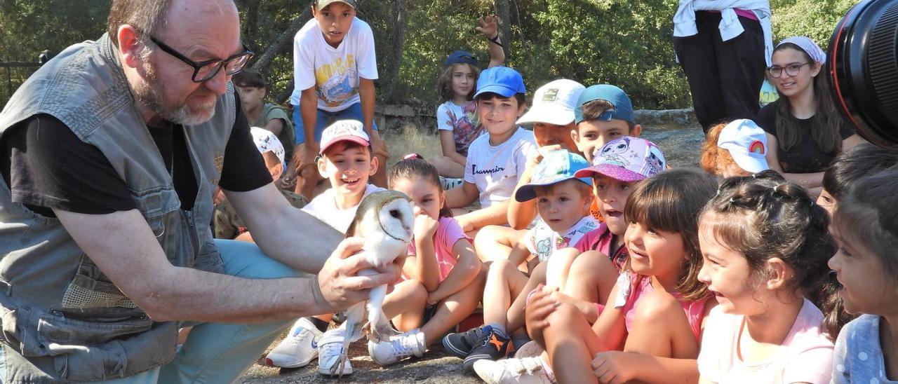 El veterinario Juan José Gómez enseñando la lechuza a los niños y niñas.   | // FERNANDO CASANOVA