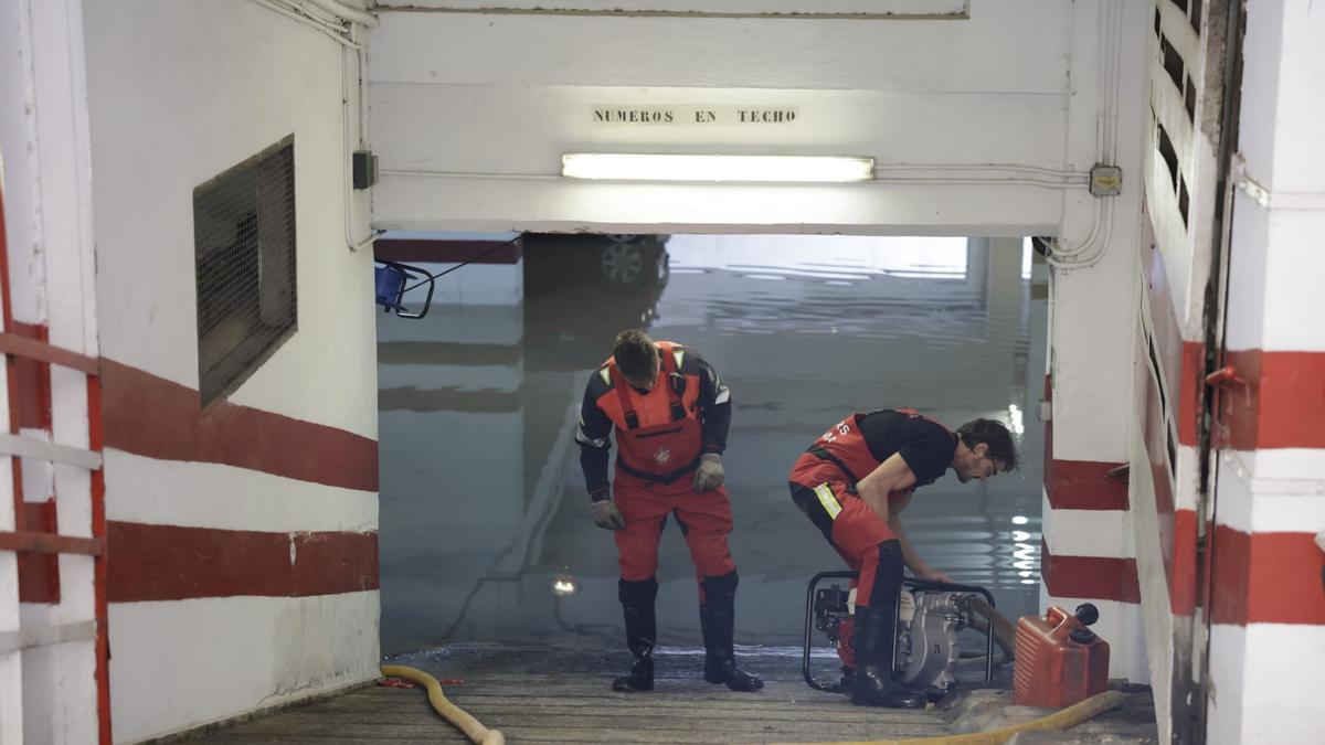 Bomberos achican agua de un garaje subterráneo.