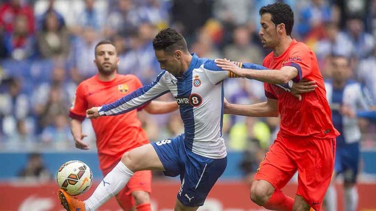 Sergio García trata de controlar el balón ante la presión de Busquets, durante el Espanyol-Barça