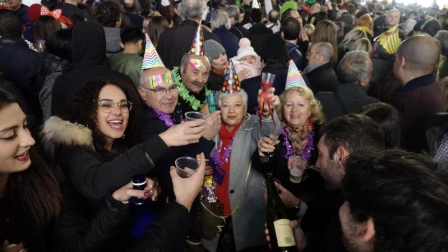 Varias personas brindan en la Nochevieja celebrada en la plaza de la Constitución.