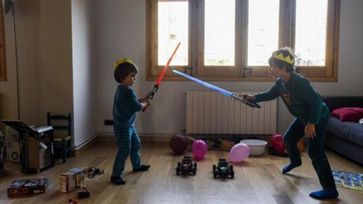 Guerreros 8 Los 'jedi' Miquel y Mateu estrenan sus espadas láser en su piso de Barcelona, ayer.