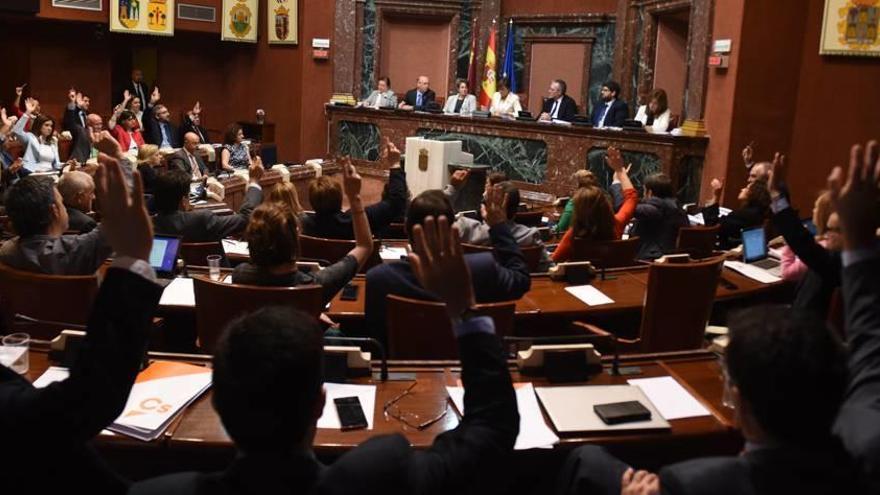 Los diputados regionales alzan la mano para votar a favor de la modificación del Estatuto de Autonomía para la supresión de los aforamientos.