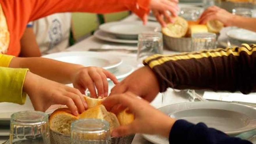 Varios niños cogen un trozo de pan en un comedor escolar // FARO