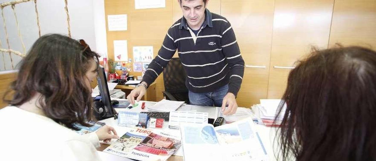 Santiago de Asla, de Turiplanet, atiende ayer a dos clientas de la agencia.