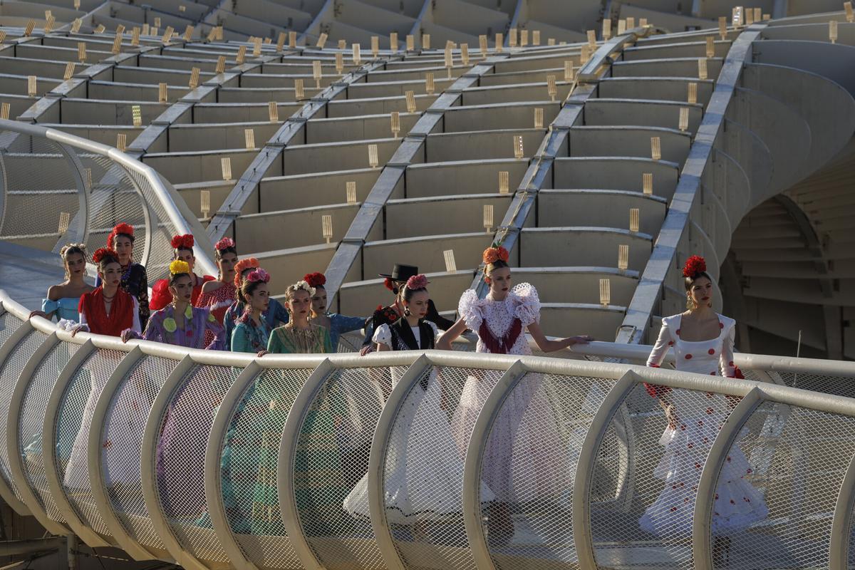 óvenes vestidas con trajes de flamenca de varios diseñadores desfilan este lunes por el mirador de Las Setas de Sevilla durante la presentación de la Semana Internacional de la Moda Flamenca (SIMOF) en su edición de 2026