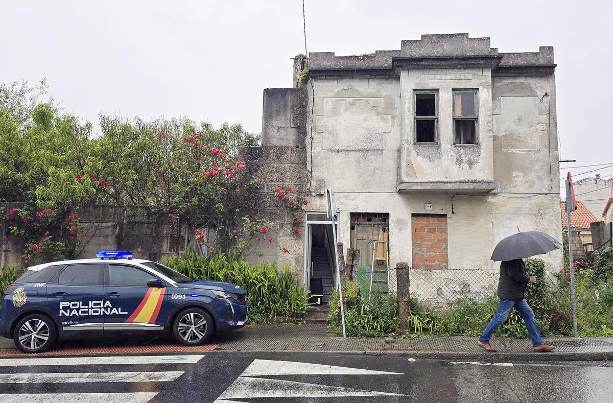 La vivienda okupada tras el incendio en calle Ceboleira, custodiada por una patrulla de la Policía Nacional