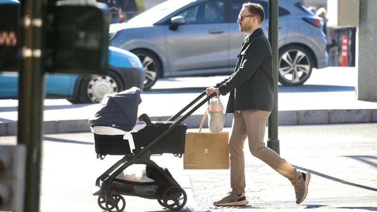 Un padre con un carrito de niño.