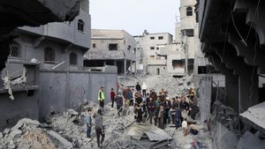 Un grupo de palestinos supervisa una zona recién bombardeada en el campo de refugiados de Nuseirat, en el centro de la Franja de gaza, este sábado.