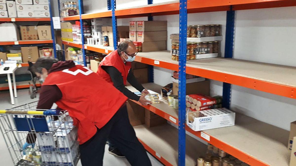 Los dos voluntarios preparan uno de los carros de comida que entregarán a una familia necesitada. | E. P.