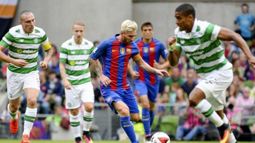 Messi, con cambio de imagen, golpea el balón entre dos jugadores del Celtic.