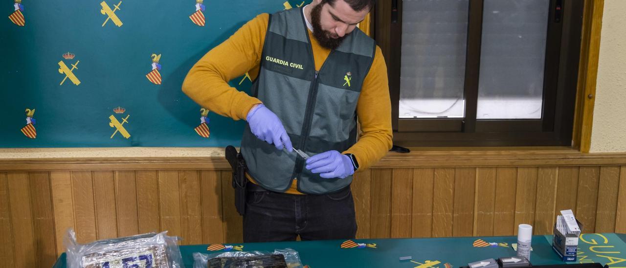 Un Guardia Civil exhibe una muestra de las 5,5 toneladas de cocaina, el mayor alijo de la historia en el puerto de València, intervenido en 2022.