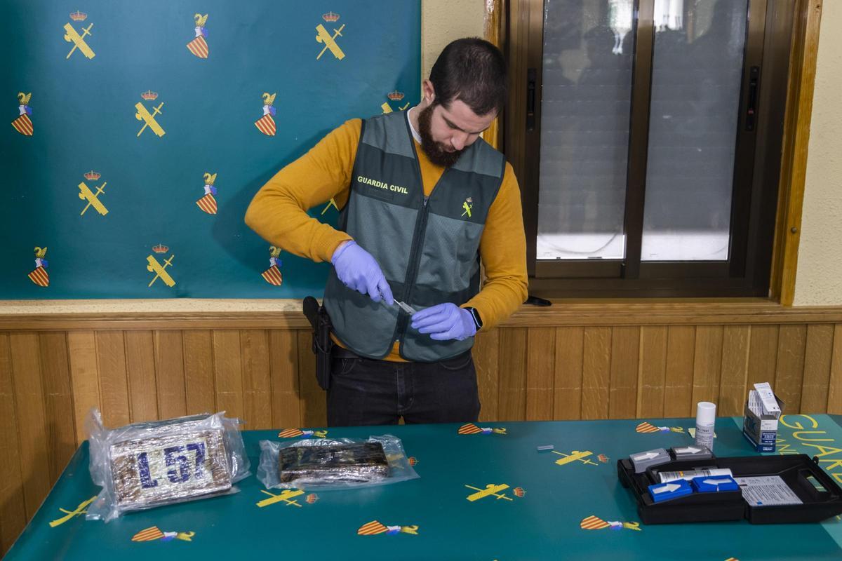 Un Guardia Civil exhibe una muestra de las 5,5 toneladas de cocaina, el mayor alijo de la historia en el puerto de València, intervenido en 2022.
