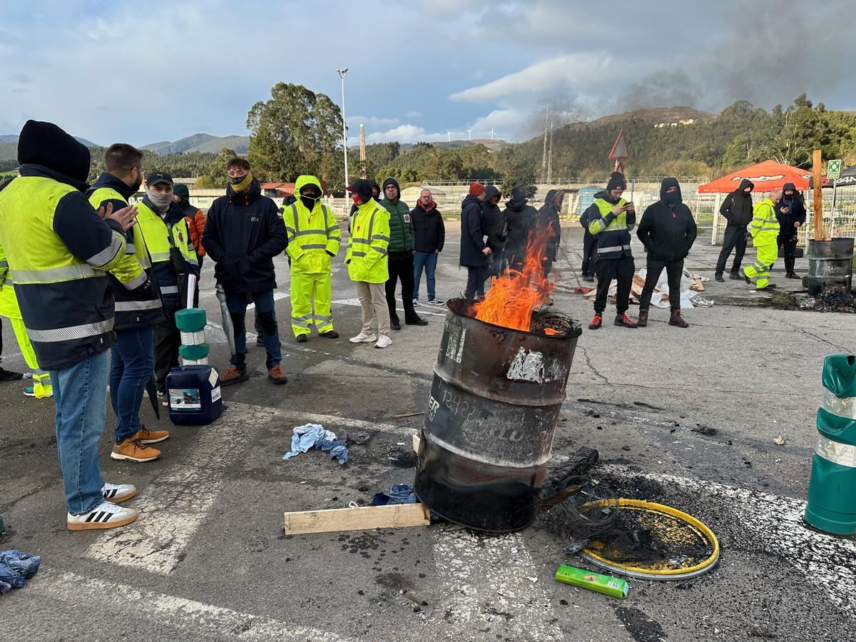 Trabajadores cerca del fuego, en el acceso de la fábrica.