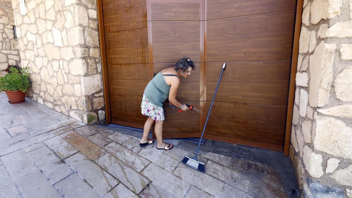 María Pilar Lahuerta retira los restos de ceniza de la puerta.