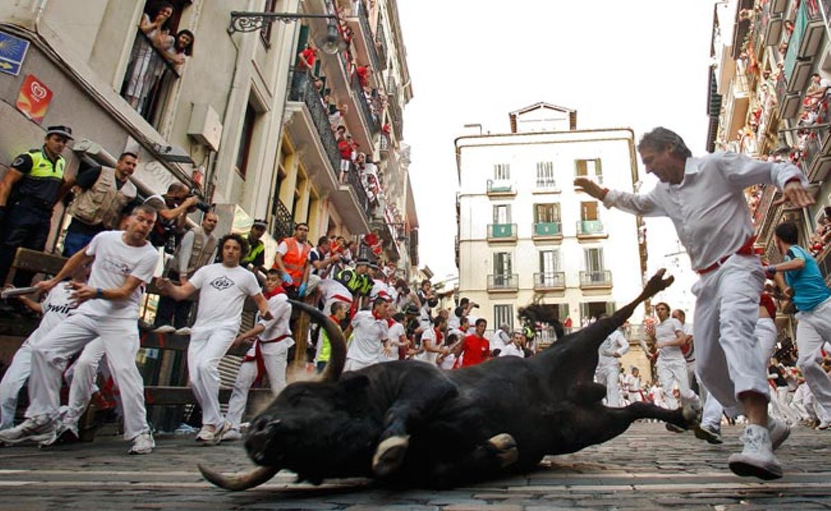 Un toro rellisca al revolt d’Estafeta durant el sisè ’encierro’ dels ’sanfermines’ a Pamplona.