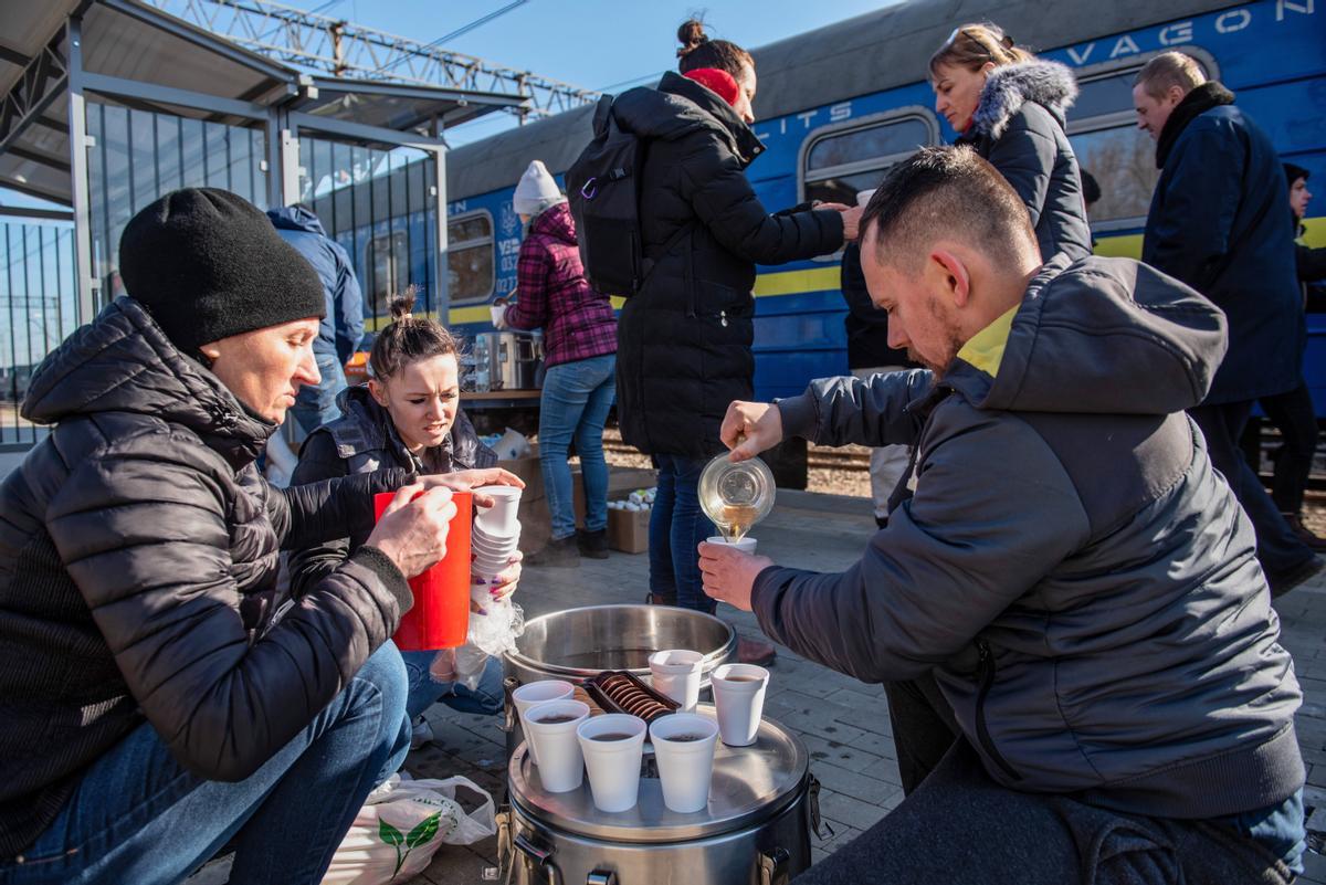 Refugiados ucranianos toman una bebida caliente en la frontera de Dorohusk.