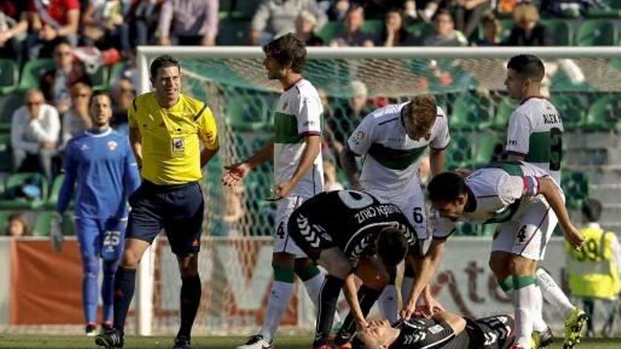 El árbitro Figueroa se dispone a mostrar la roja a Mandi, mientras Víctor Curto está tumbado en el suelo tras recibir un cabezazo.