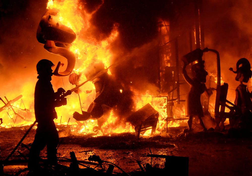 A fireman sprays water at figures of a monument ...