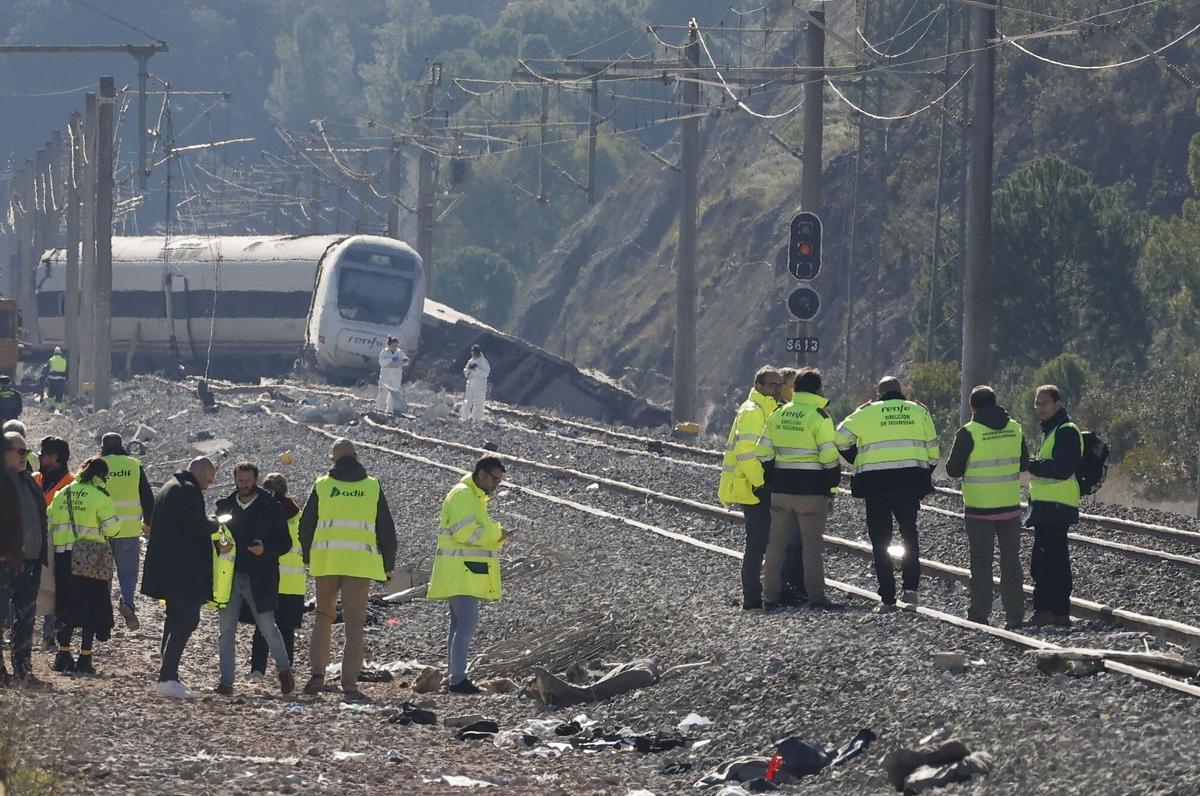 Varias personas trabajan junto a los vagones siniestrados del accidente ferroviario en Adamuz (Córdoba) del pasado domingo que ha dejado al menos hasta este martes 41 víctimas mortales.