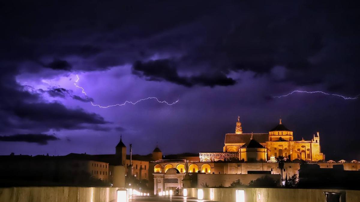 Dos rayos cruzan el cielo de Córdoba en una imagen tomada desde el Puente Romano con la Mezquita´Catedral de fondo.