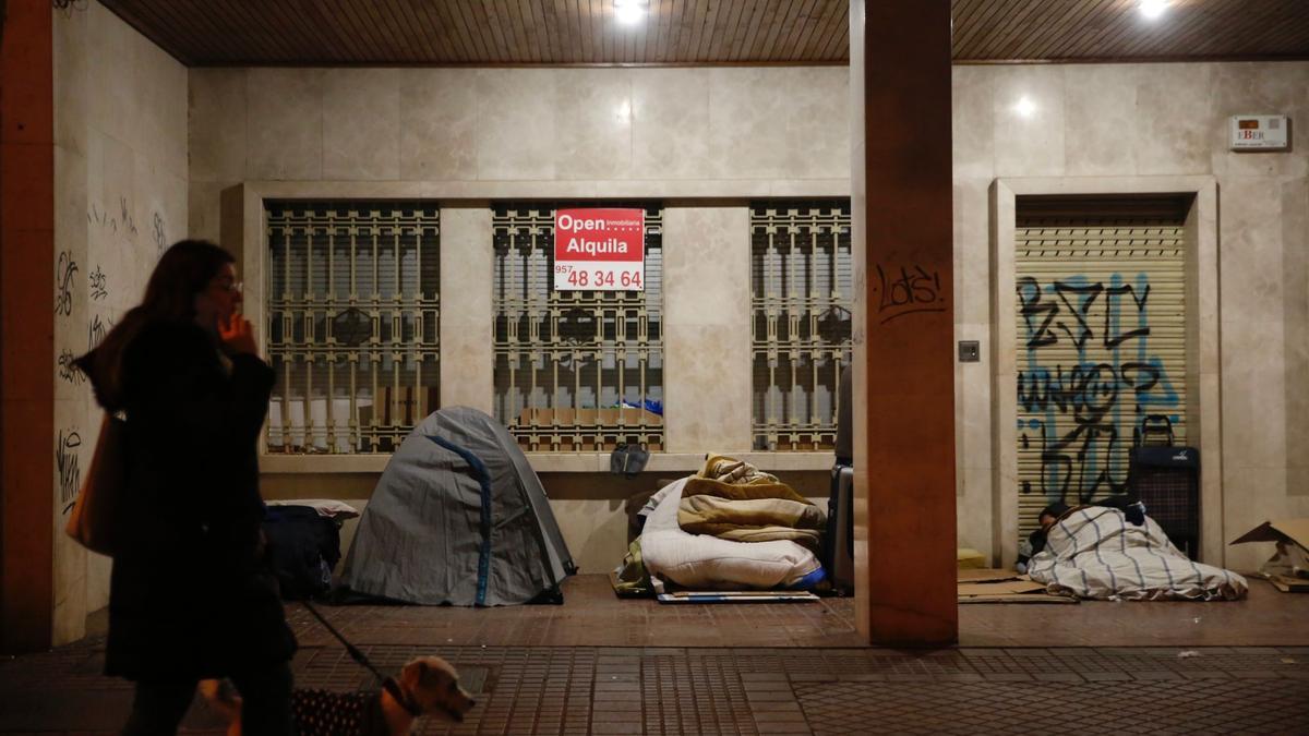 Tienda de campaña instalada, junto a otros colchones, en un soportal de Ollerías.