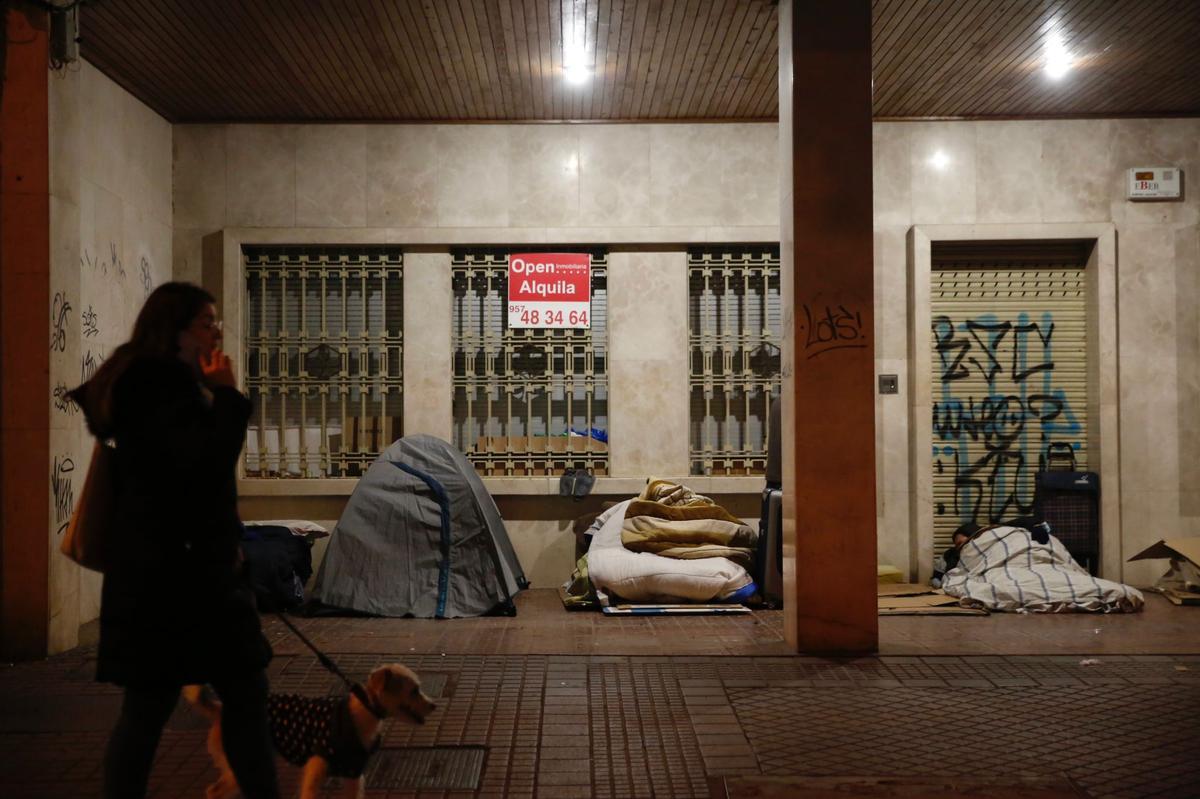 Tienda de campaña instalada, junto a otros colchones, en un soportal de Ollerías.