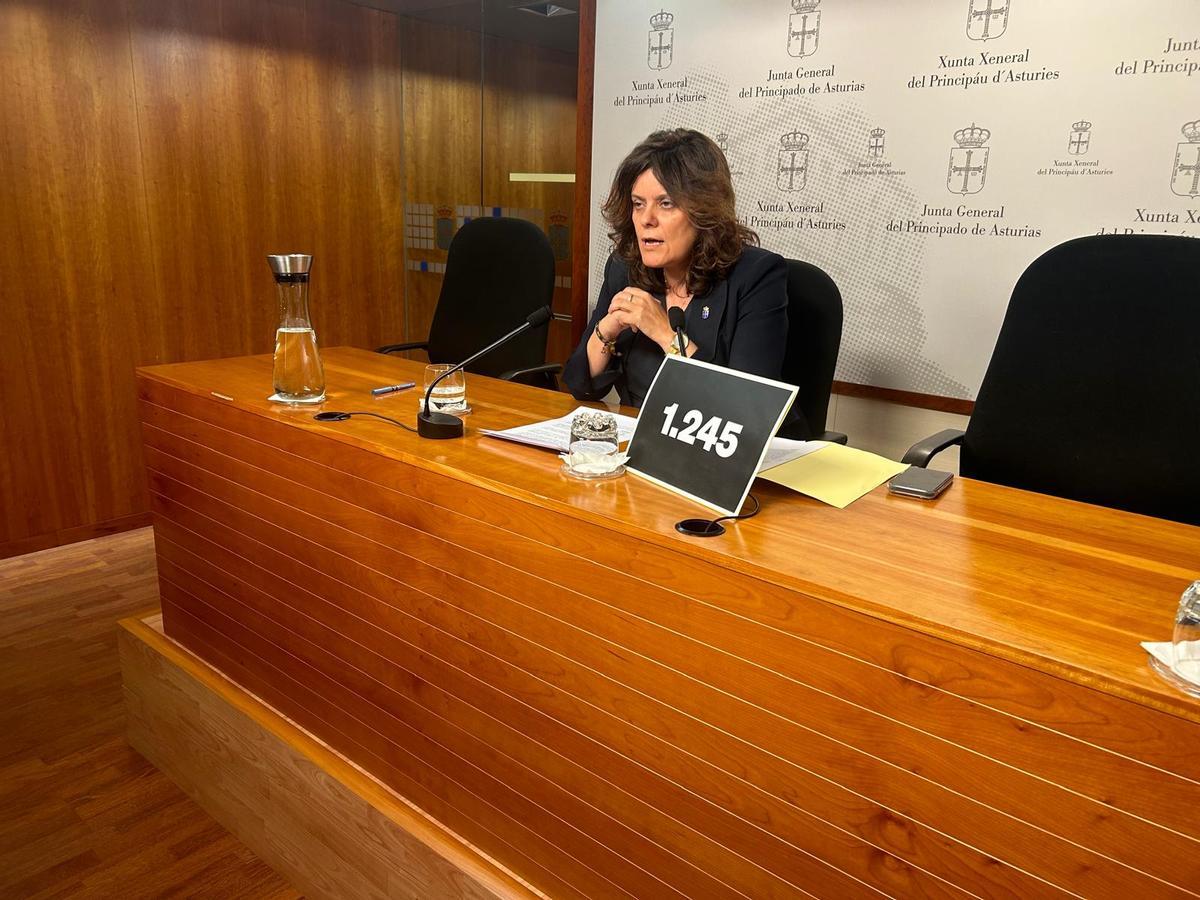 Beatriz Polledo, durante la rueda de prensa, con un cartel con la cifra de fallecidos que no recibieron valoración de la dependencia.