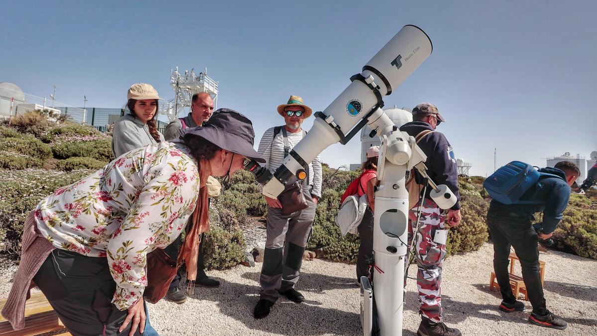 Una mujer mira a través del telescopio.