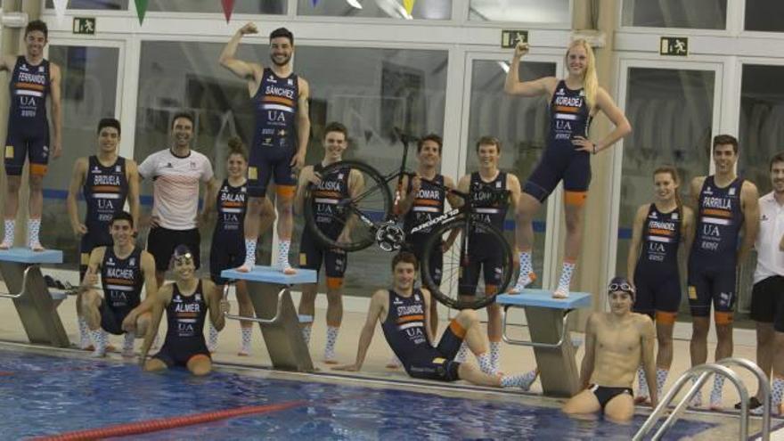 El equipo de triatlón de la UA posa en la piscina universitaria con su nueva equipación.