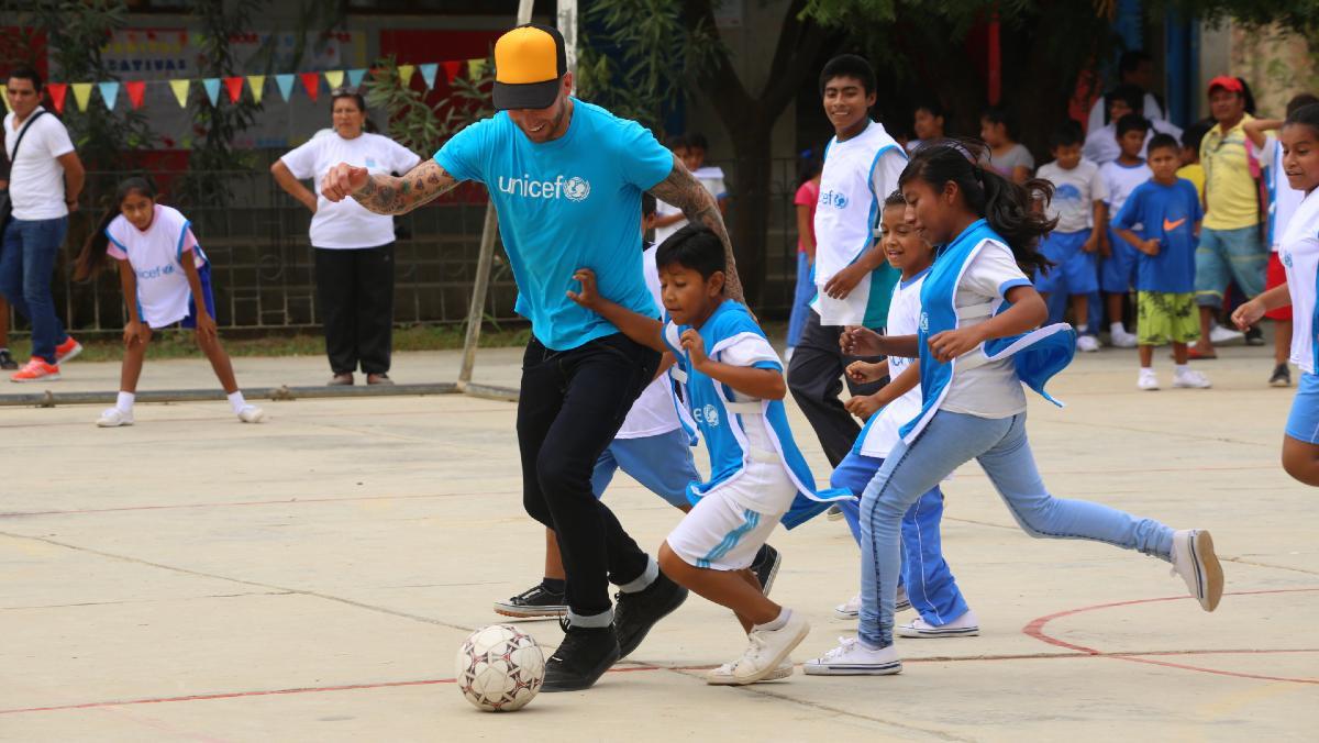 Sergio Ramos juega con unos niños durante una visita a Perú como embajador de Unicef.