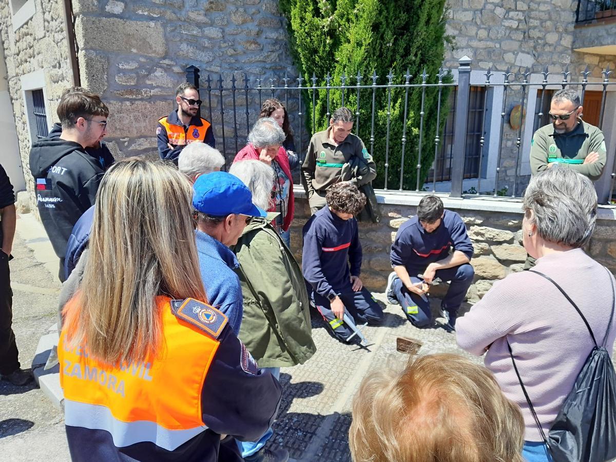 Vecinos prestan atención a los consejos de los bomberos durante la jornada de concienciación.