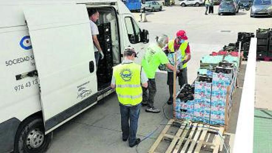 Un grupo de voluntarios entregan alimentos en Zaragoza. | ÁNGEL DE CASTRO