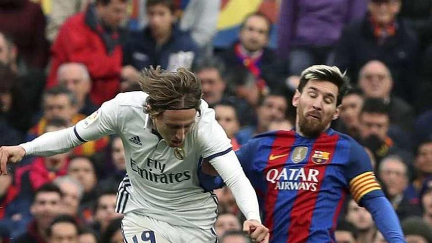 Modric golpea el balón ante Messi. // Efe