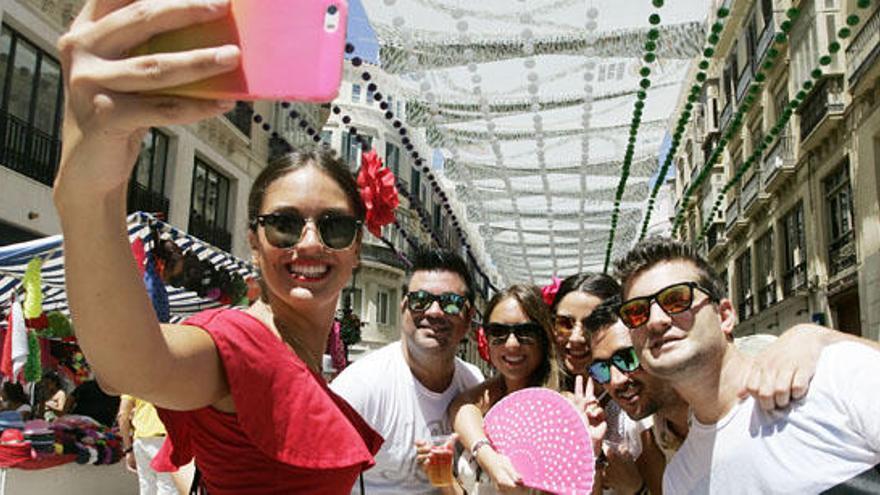 Varios jóvenes se hacen un selfi en la calle Larios, el año pasado.