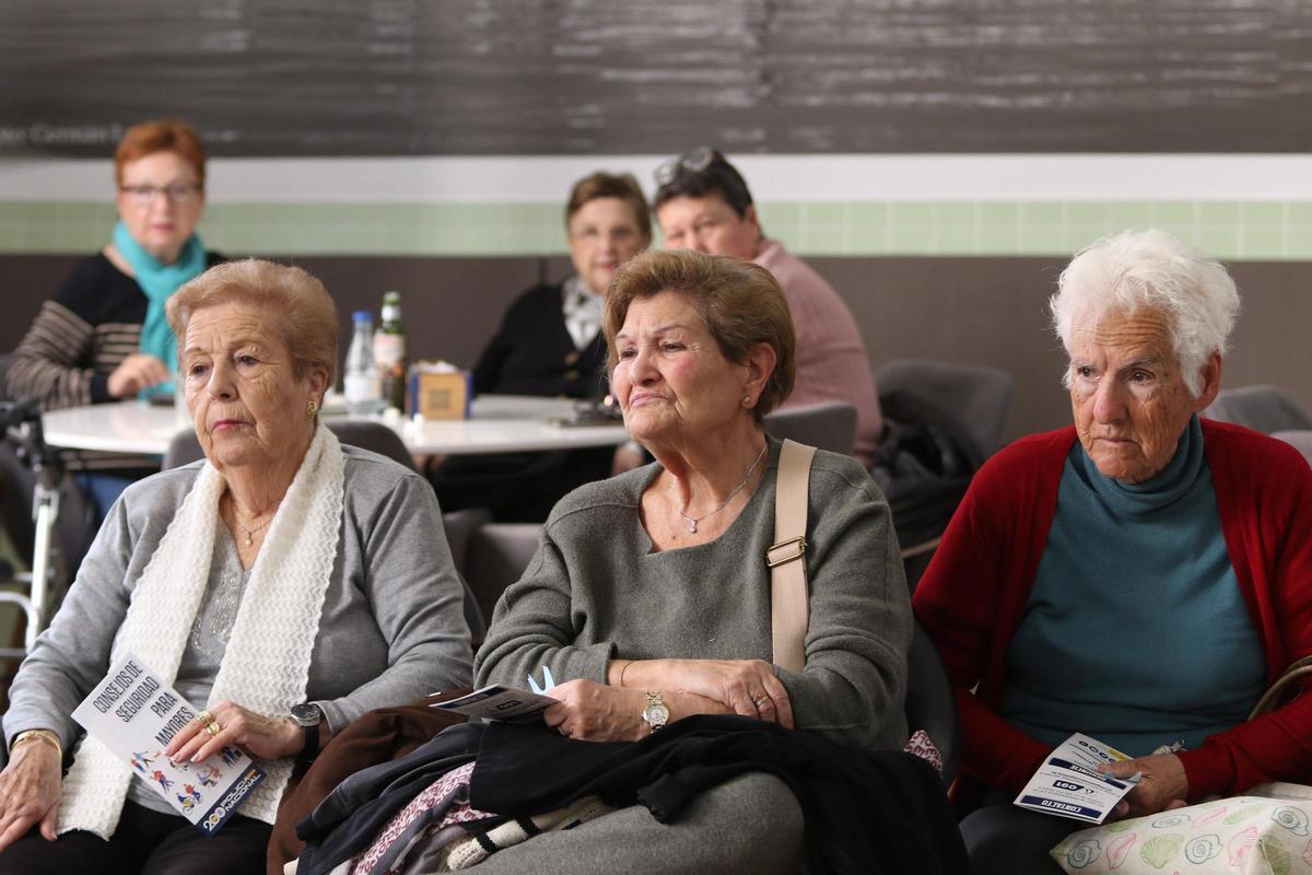 Varias de las asistentes escuchan con atención la charla del agente.