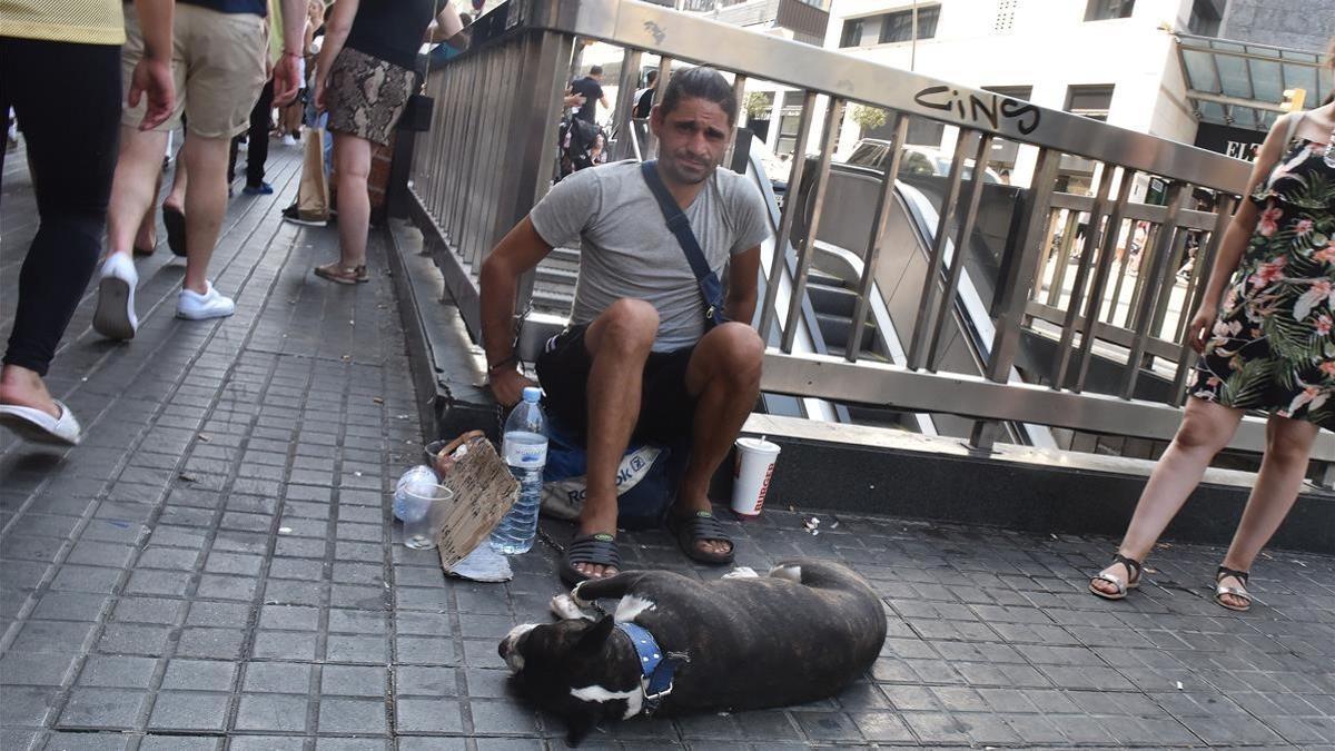 Uno de los individuos que exhiben de manera ambulante perros con fines lucrativos, con un boston terrier en la esquina de la calle Pelai con La Rambla.