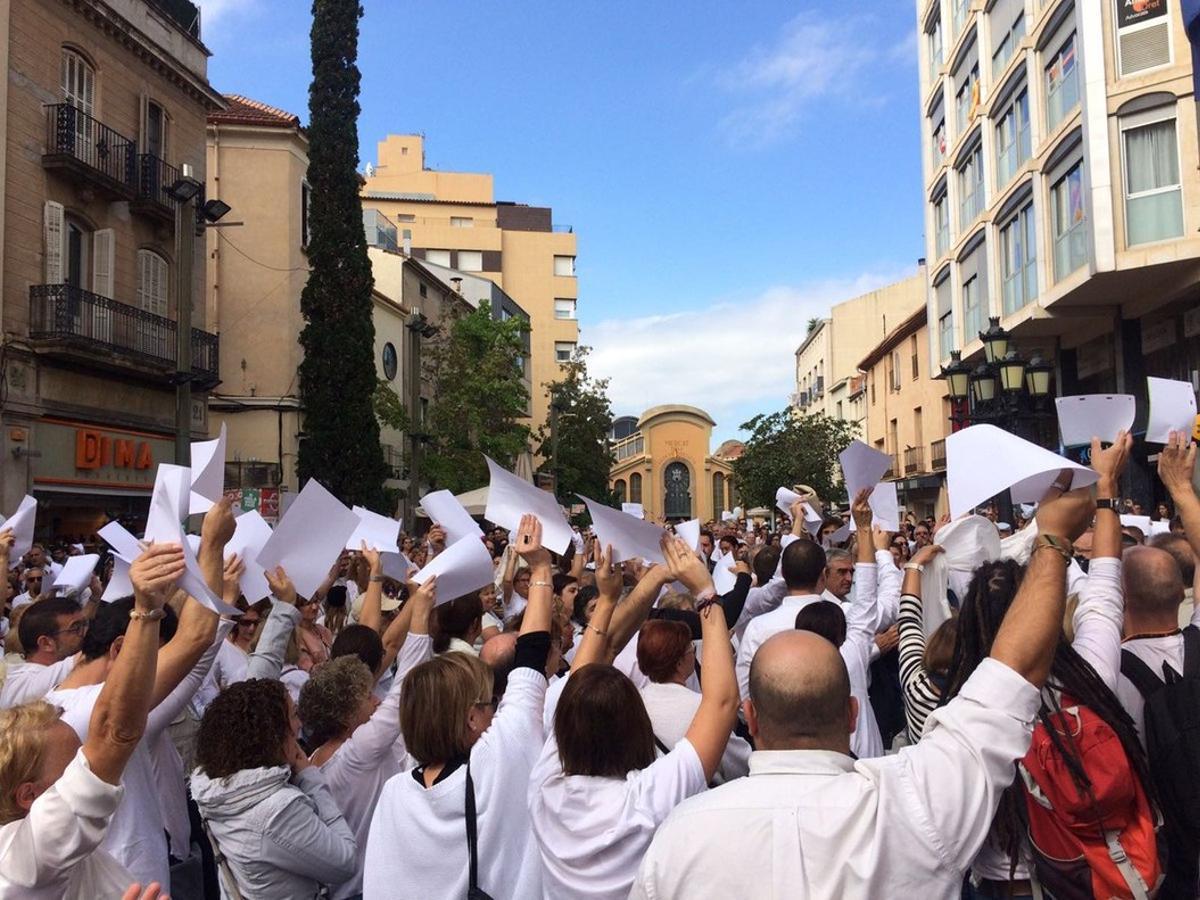 Los concentrados en la manifestación a favor del diálogo en Terrassa alzan sus brazos con papeles en blanco. 