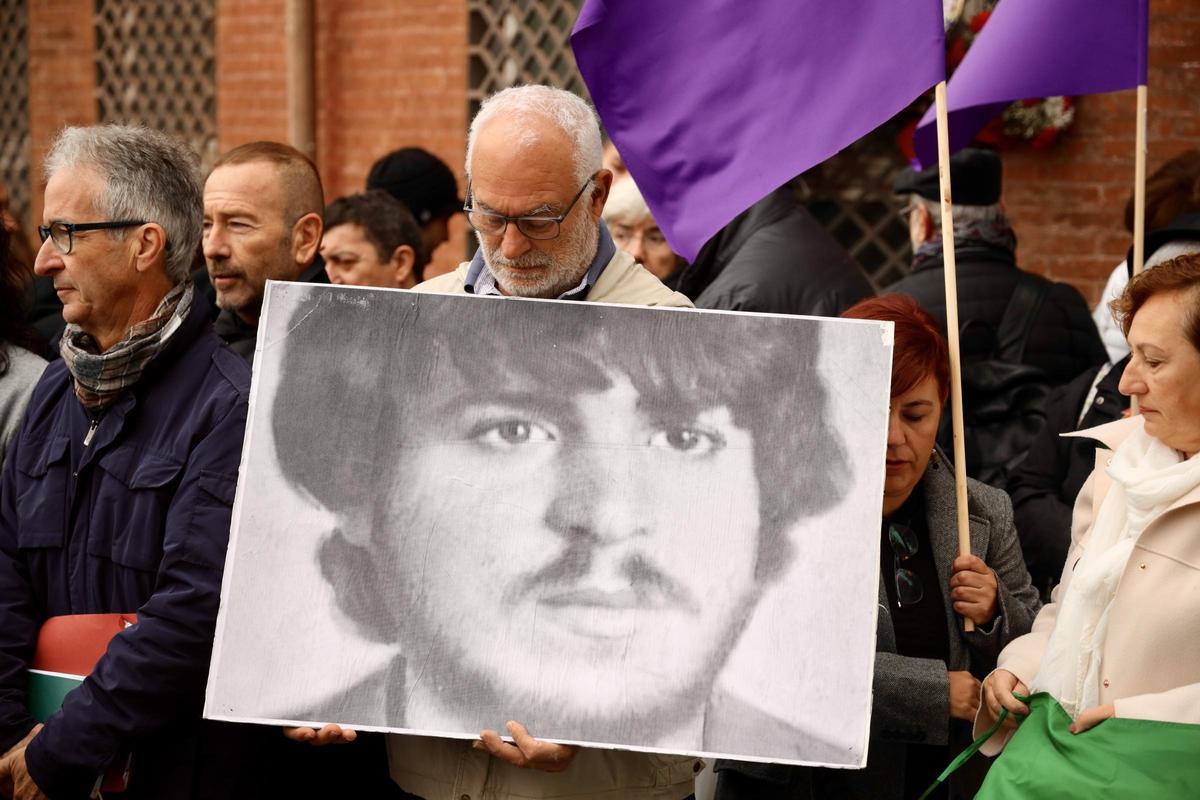 Un hombre porta una fotografía del homenajeado.