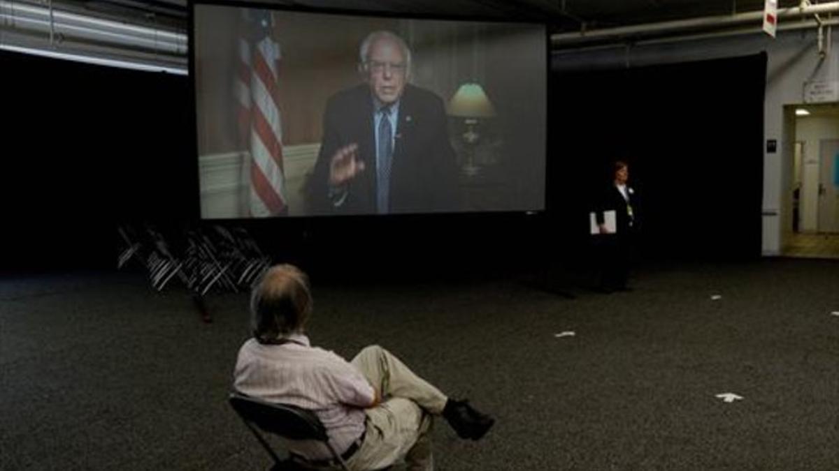 Sanders (en la pantalla) interviene 'on line' en una convención en New Hampshire.