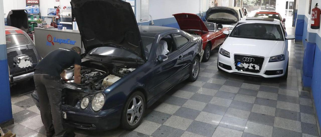 Un mecánico arreglando ayer uno de los coches inmovilizados en el taller Lupacar.