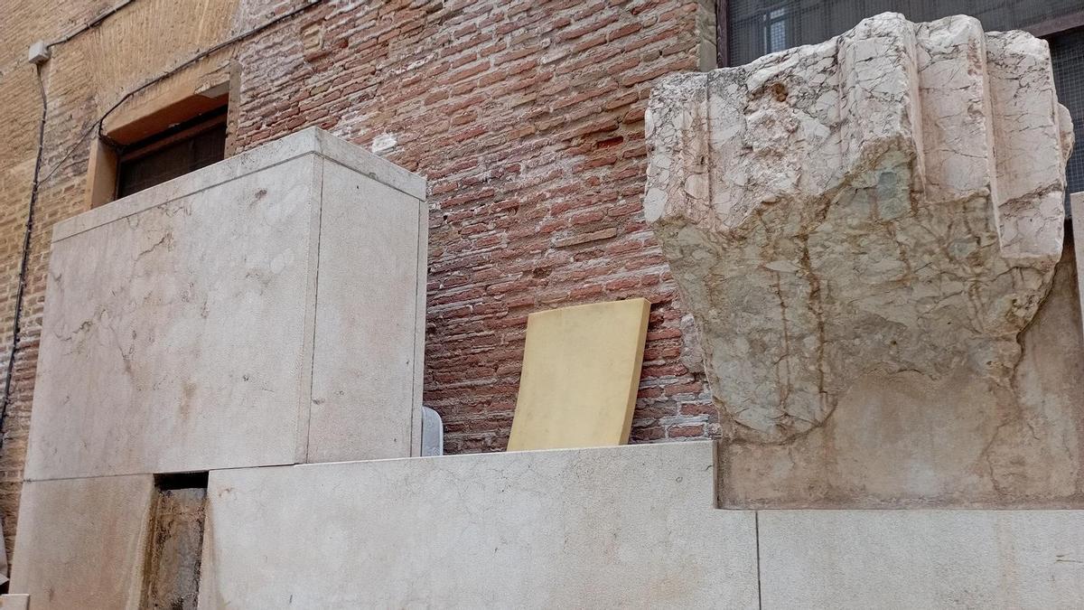 Detalle de la fuente con uno de los mármoles del palacio de los Larios y avíos de indigentes, la semana pasada.