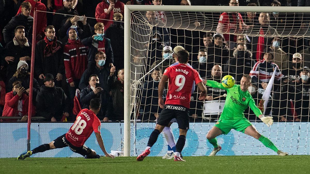 Barcelona's German goalkeeper Marc-Andre ter Stegen (R) deflects a shot from Real Mallorca's Spanish defender Jaume Costa (L) during the Spanish League football match between RCD Mallorca and FC Barcelona at the Visit Mallorca stadium in Palma de Mallorca on January 2, 2022. (Photo by JAIME REINA / AFP)